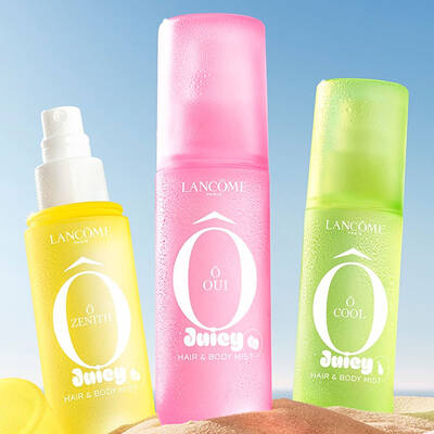 Two yellow bottles, one perfume rectangular bottle with a textured design and one spray bottle with a yellow cap on the side, standing on a sandy beach. A folded pink striped beach towel lies next to the bottles. In the background, there is a clear blue sky and the ocean.