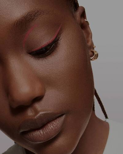 Close-up of a model featuring a sharp, thin line of pink eyeliner.