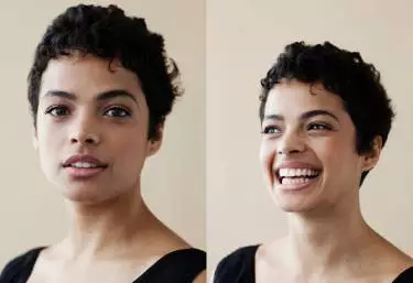 A close-up portrait of a person with short, curly hair, showing two expressions: a calm smile on the left and a broad smile on the right, against a light beige background.