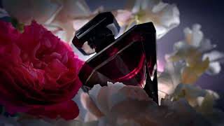 A sleek black perfume bottle nestled among pink and white flowers, exuding an elegant and luxurious atmosphere.