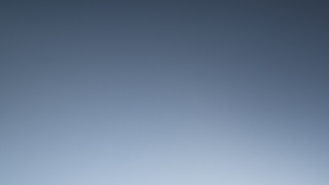 A close-up of Lancome makeup products, including a compact, foundation, and a concealer tube, set against a warm brown background.