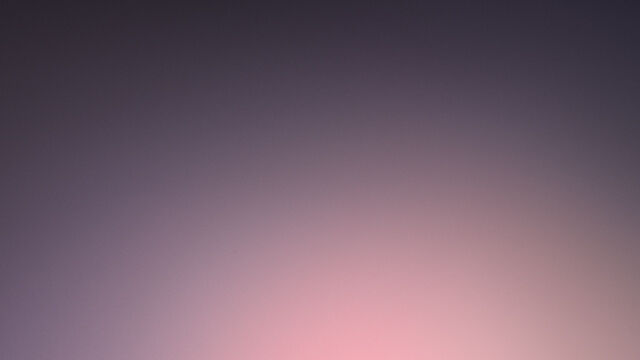 A sleek black mascara tube standing upright against a gradient background, with a fine applicator brush beside it.