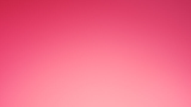 A red gift box with a ribbon, featuring the Lancome logo, set against a pink background.