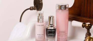 Three bottles of Lancome skincare products, including Hydra Zen, Advanced Genifique, and Tonique Confort, displayed on a bathroom countertop.