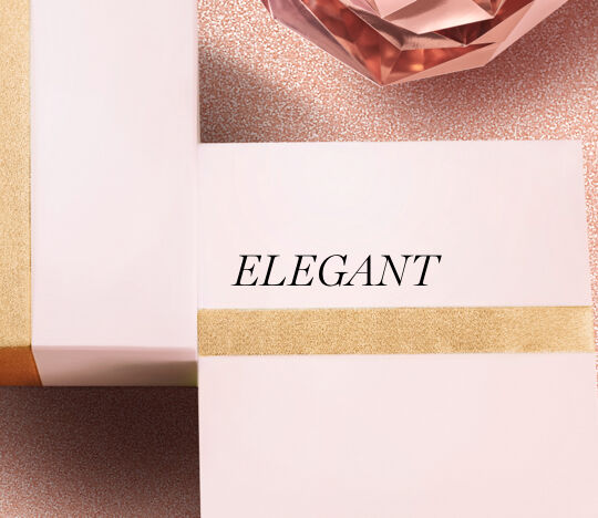 A close-up of elegantly wrapped gift boxes with a gold ribbon against a textured pink background, featuring the word "ELEGANT" prominently displayed.