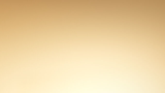 A close-up of two luxurious Lancome Absolue skincare bottles against a golden background.