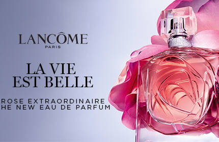 A elegant perfume bottle adorned with pink rose petals, set against a soft gray background.