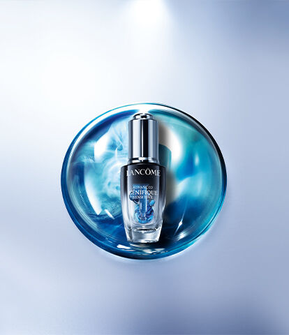 A sleek bottle of serum placed on a circular blue and white textured surface, with a soft, blurred background.