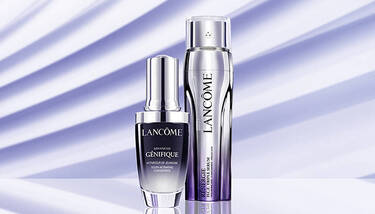 Two Lancome serums, Advanced Genifique and Renergie H.C.F. Triple Serum, are showcased against a light purple background with diagonal shadow stripes.