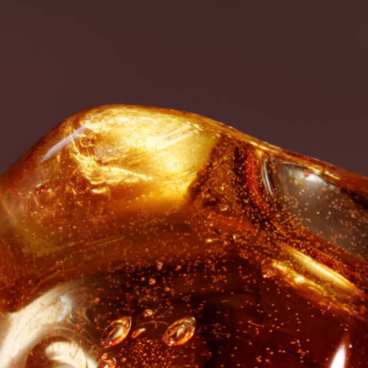 Close-up of a polished amber piece, showcasing its rich golden hue and trapped air bubbles.