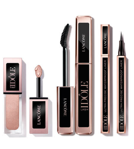 A variety of Lancome makeup products including a lip tint, a mascara, and a waterproof eyeliner, all featuring elegant packaging with a rose gold color scheme.