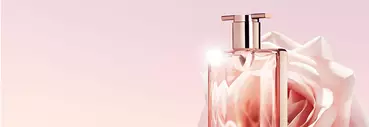 A close-up of a stylish perfume bottle with a rose in the background, set against a soft pink gradient backdrop.