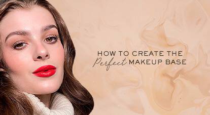 A close-up of a woman with long, wavy hair and bold red lipstick, set against a soft beige background. The text beside her reads, "How to create the perfect makeup base."
